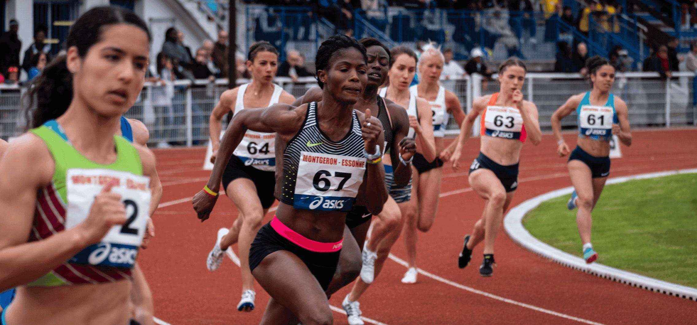 Group of female athletes in a sprint race on an athletics track