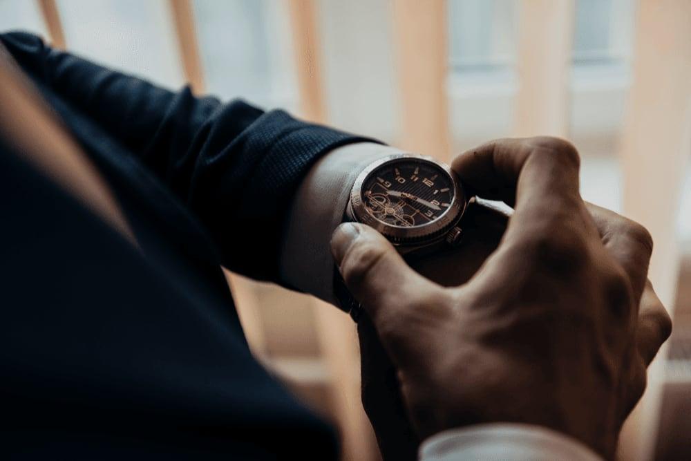 person in a suit looking at their watch