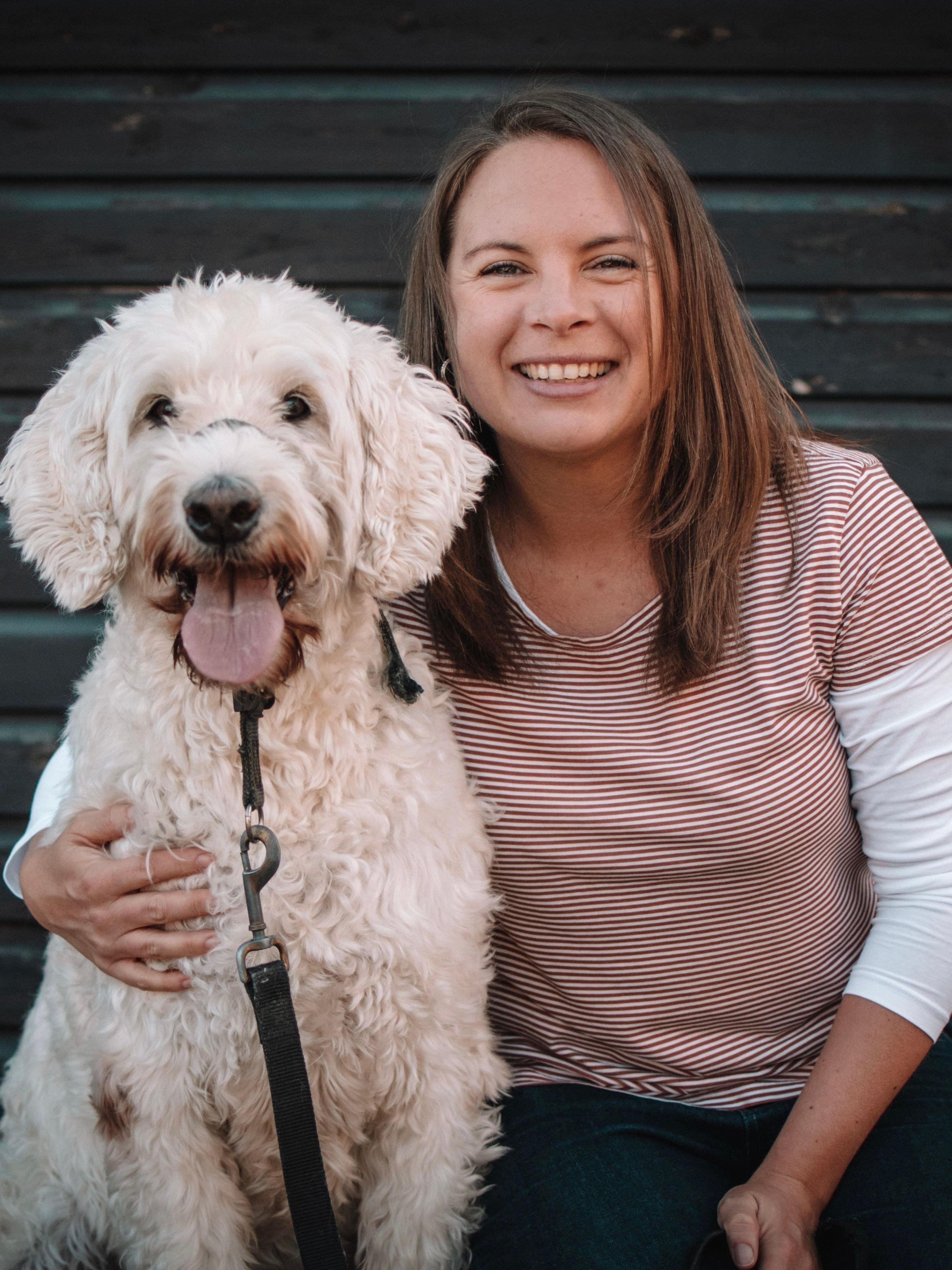 Freestyle Office Manager Claire de Scarfo smiling and cuddling her big white fluffy dog Tess.